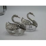 A pair of silver and glass swan pin dishes. The swans having decorative, pierced articulating wings
