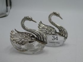 A pair of silver and glass swan pin dishes. The swans having decorative, pierced articulating wings