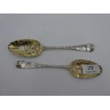 Two Georgian silver berry spoons with heavily decorative handles of flares, and gilt bowls. One hall