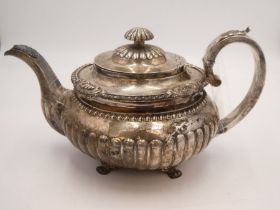 A large Irish Georgian silver teapot having half reeded, baluster body, acanthus leaf decorative han