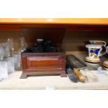 A wooden box containing binoculars, some vintage tools and a fishing rod