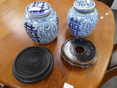A pair of Chinese blue and white ginger jars, with wooden stands