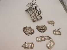 A decorative silver toast rack by Atlein Brothers, Sheffield 1907, standing on four ball feet. With