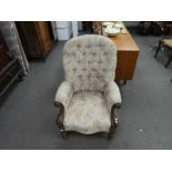 A Victorian mahogany button back armchair having turned front legs