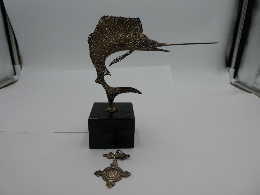 A white metal Sailfish on a marble style plinth. Having ornate pierced design of pretty decoration '