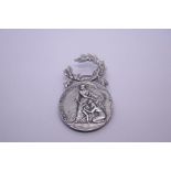 White metal, possibly silver, French Police badge, depicting a warrior protecting mother and child,