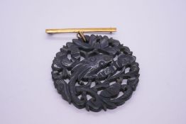 9ct yellow gold bar brooch hung with a large, carved circular Jade panel, decorated birds and foliag