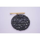 9ct yellow gold bar brooch hung with a large, carved circular Jade panel, decorated birds and foliag