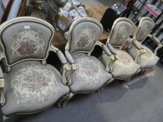 A set of 4 cream painted and gilt decorated French open armchairs having tapestry style upholstery