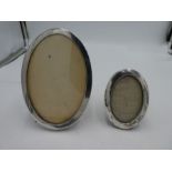 A silver oval photoframe hallmarked Chester 1915, possibly J and R Griffith. With another larger pho