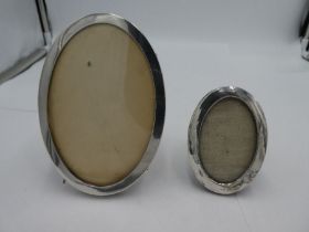 A silver oval photoframe hallmarked Chester 1915, possibly J and R Griffith. With another larger pho