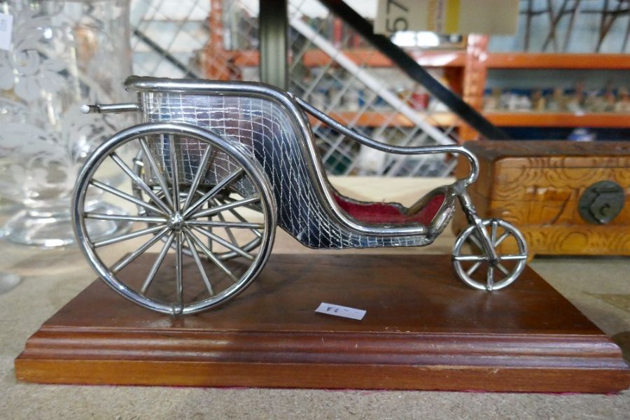 A reproduction metal figure on plinth of a Victorian bath chair