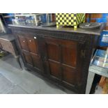 An antique oak two door cupboard, possibly late 18th century, having carved decoration with thumbnai