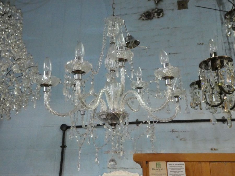 A modern 9 branch chandelier and one other 6 branch example, having smokey finish