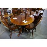 An Oak circular tripod dining table and a set of three stick back chairs