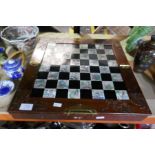 A carved oriental chess board and pieces