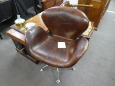 A modern brown leather revolving chair on chrome style base
