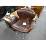 A modern brown leather revolving chair on chrome style base