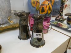 A pair of silver plated stirrup cup decorated fox heads, and three other items