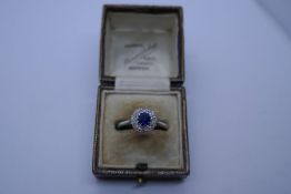 Pretty 18ct and platinum and diamond cluster ring, central 0.66ct round faceted sapphire surrounded