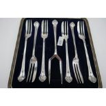 An attractive cased set of six silver cake forks and a serving fork. Hallmarked Sheffield 1923, Lee