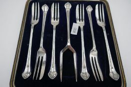 An attractive cased set of six silver cake forks and a serving fork. Hallmarked Sheffield 1923, Lee