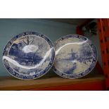 Two large Delft wall plates depicting woodland scenes and windmills