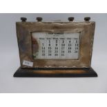 A silver mounted desk calendar on a wooden base. Hallmarked Birmingham 1913 W J Myatt and Co., 15cm