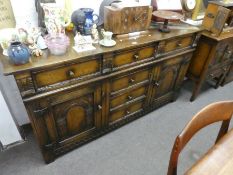 A reproduction oak sideboard having six drawers with carved decoration 167.5cms