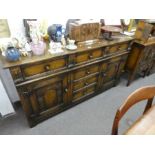 A reproduction oak sideboard having six drawers with carved decoration 167.5cms