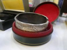 A hallmarked Silver bangle, with engraved fern leaf design, two other Silver bangles and a rolled go