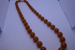 Vintage string of circular amber beads, each amber bead separated by a clear bead, 54g approx