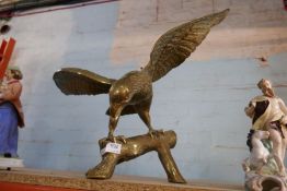 A large brass Eagle, perched on a log