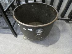 An old copper log bin with riveted design and lion mark handles