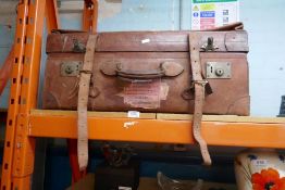 A vintage leather suitcase/trunk adorned by railway stickers including 'Southampton to Jersey', etc