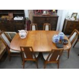 A mid century Danish teak extending dining table by Mobel Fabrik having 2 leaves and a set of 6 matc