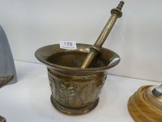 An antique brass pestle and mortar, the pestle decorated foliage and figures, possibly 18th century