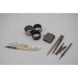 A white metal and mother of pearl quill having decorative engraved metal. With a matching pencil and