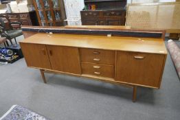 A 1970's teak sideboard having four drawers, 205cms