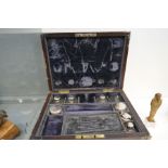 A Victorian wood and brass inlaid travelling box with silver topped bottles and similar