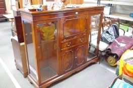 A large reproduction mahogany display cabinet, the center having cocktail section with drawer and cu