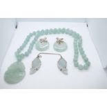 Jade bead necklace hung with a carved pendant, pair circular earrings and a cloak fastener with 2 ca