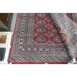 A modern Bokhara rug, the central field having three rows of elephant pad medallions, 271 x 184 cms