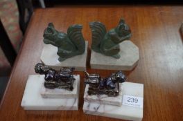 Two pairs of French Art Deco bookends, one of lying cherubs the other of squirrels eating nuts