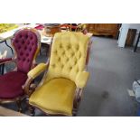 A Victorian mahogany button back armchair having scroll arms