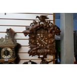 A carved Black Forest? cuckoo clock and a brass and wood clock marked Warmink, Holland