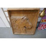 A carved plaque depicting horses head