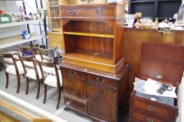 A reproduction mahogany cupboard and a similar bookcase with two drawers