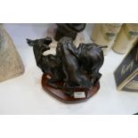 A 20th Century bronze sculpture of lion attacking buffalo on mahogany shaped plinth
