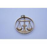 9ct yellow gold circular pendant depicting balance scales, marked 375, approx 8.4g